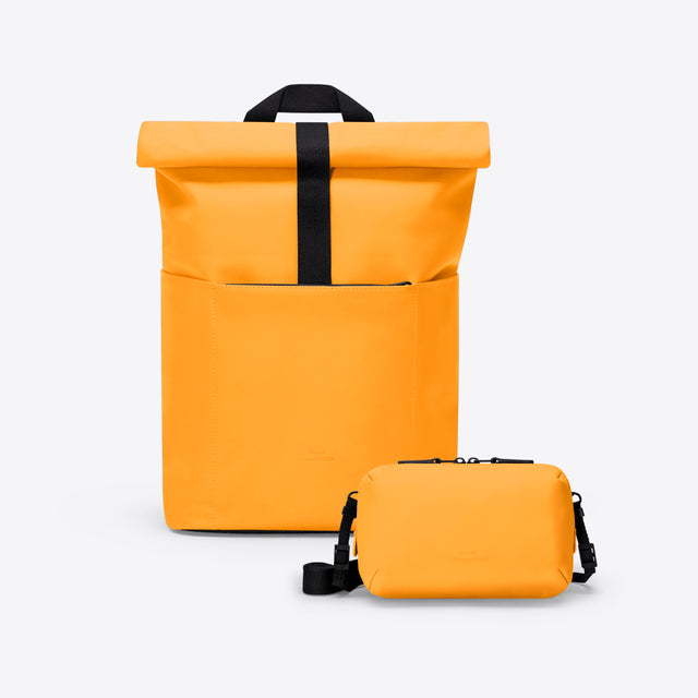 Orange roll-top backpack with a smaller orange pouch on a white background